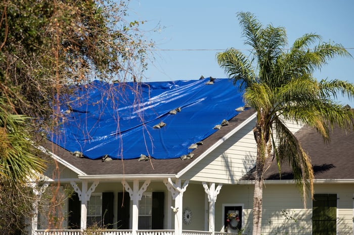 damaged-in-hurricane-house-roof-covered-with-blue-2024-12-06-05-01-07-utc-1